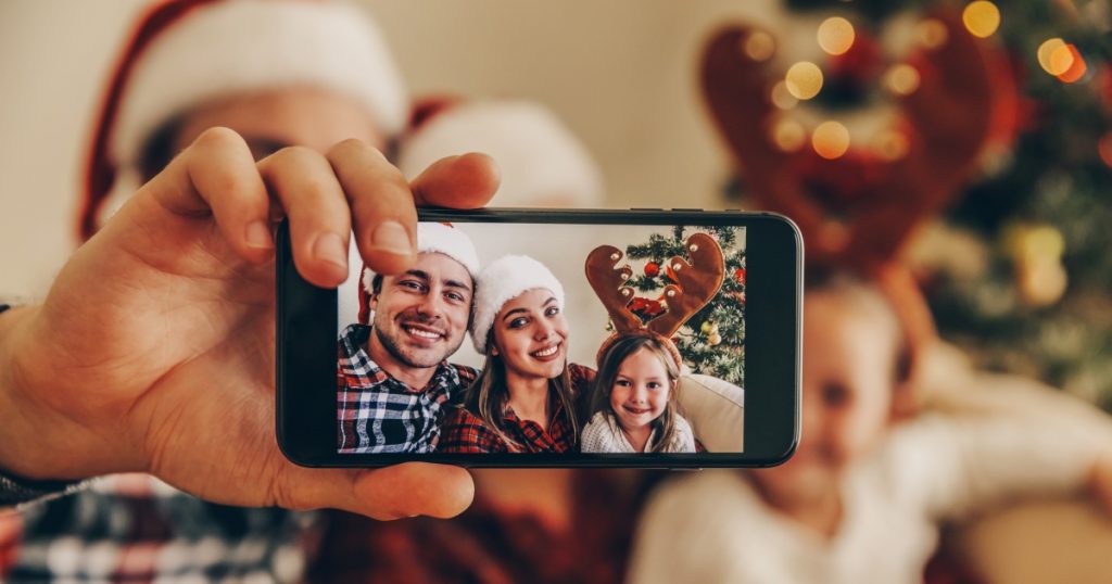 famiglia che scatta un selfie di natale da pubblicare sul web